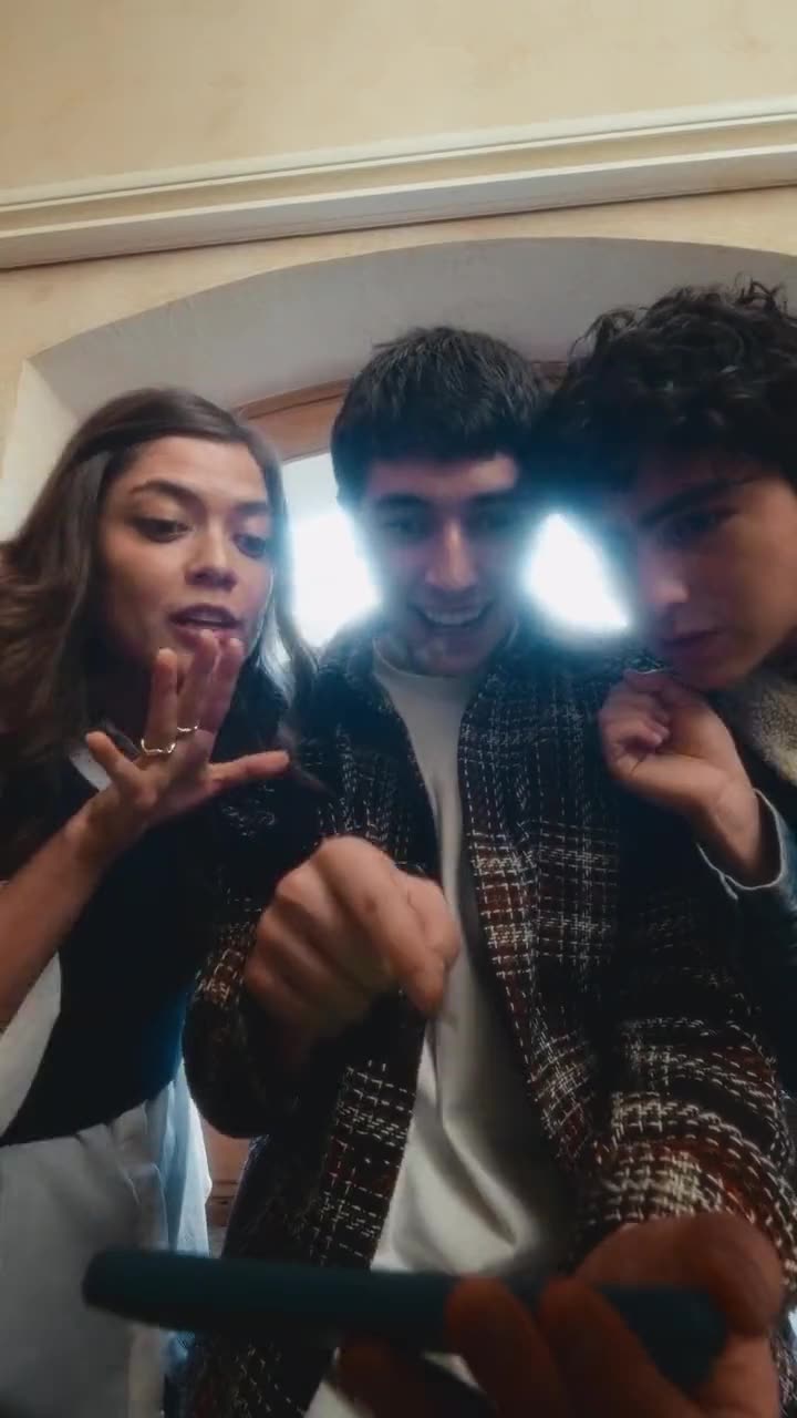 Tres amigos iluminados por la pantalla del celular mientras ven el partido