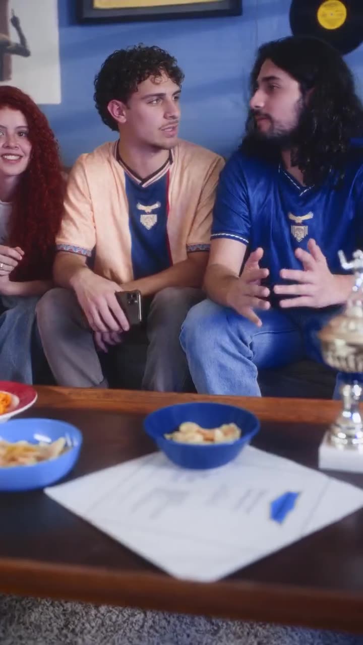 Tres amigos iluminados por la pantalla del celular mientras ven el partido