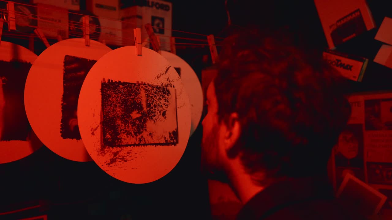 Fotógrafa revisando negativos en el cuarto oscuro